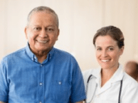 Elderly man smiling with a female healthcare professional