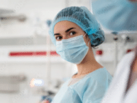 Female surgeon wearing surgical mask and cap in hospital setting